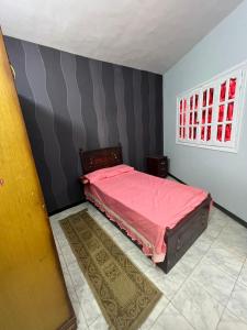 um quarto com uma cama rosa e uma janela em شقه حديثه في وسط المنصوره بالقرب من الجامعه ١٧٥ متر em Almançora