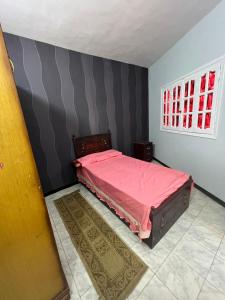 ein Schlafzimmer mit einem rosa Bett und einem Fenster in der Unterkunft شقه حديثه في وسط المنصوره بالقرب من الجامعه ١٧٥ متر in Mansoura