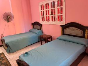 2 Betten in einem Zimmer mit rosa Wänden in der Unterkunft شقه حديثه في وسط المنصوره بالقرب من الجامعه ١٧٥ متر in Mansoura