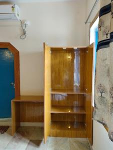 a wooden book shelf in a room with a door at Nest Home Stay in Khajurāho