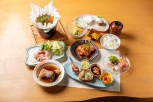 a table topped with plates of food and bowls of food at サポートイン南知多 in Utsumi