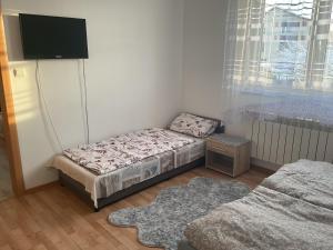 a small bedroom with a bed and a tv at Homestay Renata in Nová Lesná