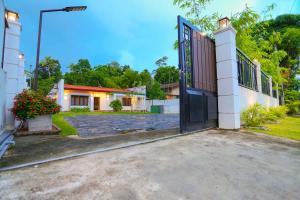 a house with a gate and a driveway at Thisath Villa in Gonapinuwala West