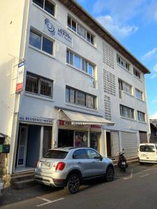 un coche plateado estacionado frente a un edificio en Residence Maeva, en Mamoudzou