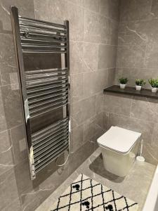La salle de bains est pourvue de toilettes blanches. dans l'établissement Bedroom 1 in Elegant 3 Bed Flat in Ramsgate, à Kent