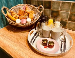 une assiette de nourriture avec un panier de pain et de jus de fruits dans l'établissement La Green suite, à Lys-lès-Lannoy
