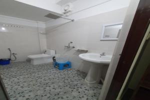 a white bathroom with a sink and a toilet at Hotel YLS, Itnagar in Itānagar