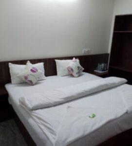 dos animales de peluche sentados encima de una cama en Hotel YLS, Itnagar, en Itānagar