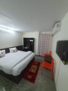 a bedroom with a large bed and a chair at Hotel YLS, Itnagar in Itānagar