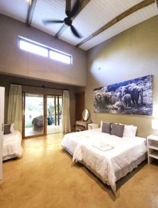 a bedroom with a large bed and a painting on the wall at Tchagra House in Hluhluwe