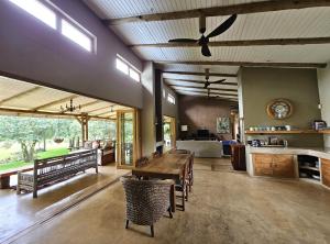 a living room with a ceiling fan and a table at Tchagra House in Hluhluwe