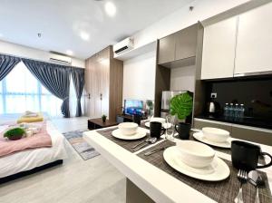 a kitchen and living room with a table with plates on it at 2Bed For 4 // KLIA Sepang Xiamen University in Sepang
