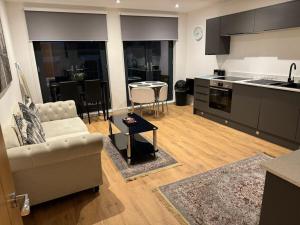 sala de estar con sofá y cocina en Bedroom 2 in Elegant 3 Bed Flat in Ramsgate, en Kent