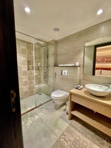 uma casa de banho com um chuveiro, um WC e um lavatório. em Best Western Maharani Bagh New Delhi em Nova Deli