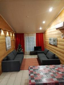 a living room with two couches and a christmas tree at Taljatie Apartments in Rovaniemi