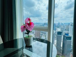 uma flor sentada numa mesa de vidro em frente a uma janela em The Platinum Kuala Lumpur by Aurora em Kuala Lumpur