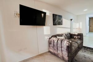 a living room with a couch and a flat screen tv at Apartamento 307 - Vista a la Represa - 1 Habitación y Sofa Cama - Rentas Cortas Gerencial in Guatapé