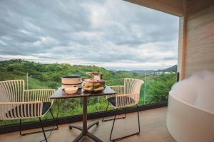 閣考島的住宿－Kirin Sky Resort，客房设有桌椅和大窗户。