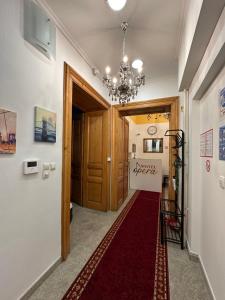 un corridoio con tappeto rosso e lampadario pendente di Hostel Opera a Lubiana