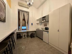 a kitchen with white cabinets and a table and a window at Hostel Opera in Ljubljana