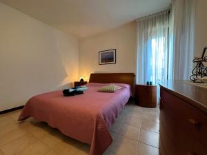 a bedroom with a bed with a red bedspread at Residenza Porta Del Mare in Lignano Sabbiadoro