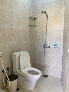 La salle de bains est pourvue d'une douche et de toilettes. dans l'établissement Reef Alhamra, à Al Hamra