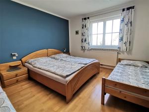 two beds in a bedroom with blue walls and wooden floors at Ferienwohnung Fuchs 