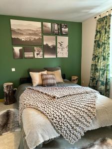 a bedroom with a large bed with green walls at Bastide du Soldat in Abreschviller
