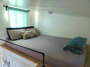 a bed with two pillows on it in a room at Tiny Home Hot Tub in Colorado City