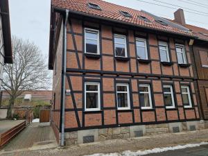 une maison ancienne avec des fenêtres blanches sur une rue dans l'établissement Ferienhaus Bavaria WR - Ferienwohnung Servus, à Wernigerode