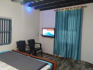 a bedroom with a bed and a flat screen tv at River view cottage in Vythiri