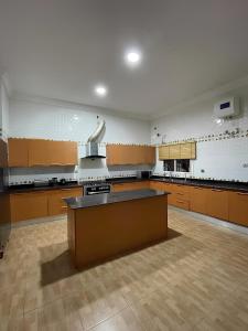 a large kitchen with wooden cabinets and a large island at Fedora Luxury Villa in Lekki Phase 1 in Lekki