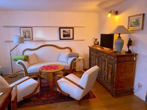 uma sala de estar com um sofá e cadeiras e uma televisão em Apartment Ad Alta Obervellach em Obervellach