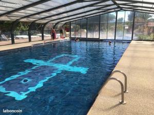 a swimming pool in a building with people in it at Kokua Développement présente MOBIL HOME résidentiel toutes options camping 4 étoiles CANET in Canet-en-Roussillon