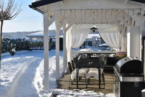um gazebo branco com uma mesa e cadeiras na neve em Serenity em Pribylina
