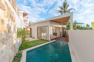 a villa with a swimming pool in front of a house at Pagi Villas by Betterplace in Canggu +28 photos