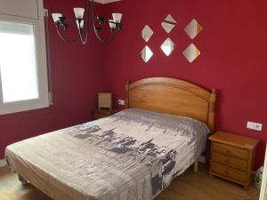 ein Schlafzimmer mit einem Bett und einer roten Wand in der Unterkunft Para amantes de espacios amplios, sol y relax in Argentona