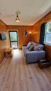 un salon avec un canapé et un parquet dans l'établissement Kereru Cottage , rural B&B, Tauranga, à Whakamarama