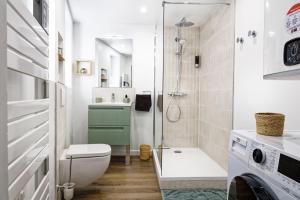 a bathroom with a shower and a toilet and a washing machine at Le Constantin - Ecrin chaleureux & confortable, centre-ville à 2 pas in Provins