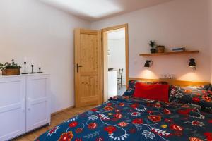 1 dormitorio con 1 cama con almohadas rojas en Pr'Kovač 2 /Perfect stay for 2, en Bohinjska Bela
