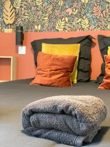 - un lit avec une couverture dans l'établissement Le Constantin - Ecrin chaleureux & confortable, centre-ville à 2 pas, à Provins