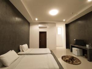 een slaapkamer met 2 bedden en een tv. bij 22 Twenty-Two Hotel ทะเวนตี้-ทู โฮเทล in Ban Pa Muat