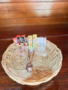 閣遙島的住宿－บ้านสวนปิยนันท์ (Baansuan Piyanan)，一个装有两杯眼镜和勺子的柳条篮子