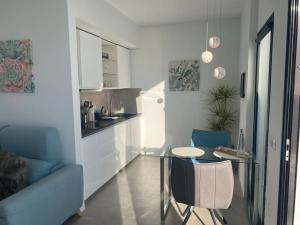 a kitchen with a glass table and a blue couch at private loft-sea views-Jacuzzi in La Asomada