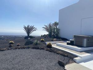 a house with a garden with cacti on the side of it at private loft-sea views-Jacuzzi in La Asomada