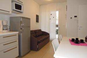 een keuken met een koelkast en een bank in een kamer bij Lovely apartment close to Bibione beach in Bibione