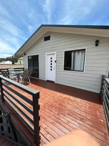 a house with a wooden deck with a patio at Peak View in Lithgow