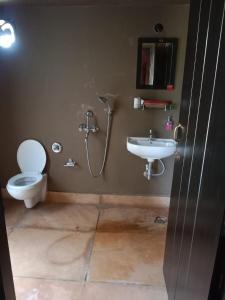 a bathroom with a toilet and a sink at Arshinagar Shilpogram in Kolkata