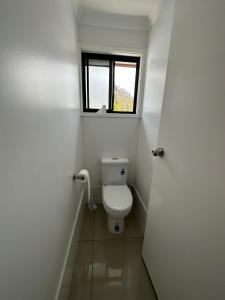 a small bathroom with a toilet with a window at Peak View in Lithgow