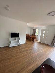 an empty living room with a flat screen tv at Peak View in Lithgow